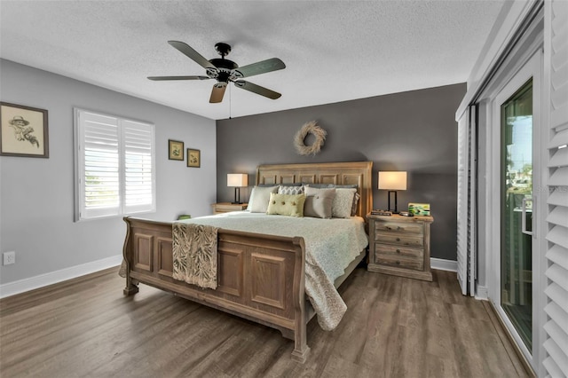 bedroom with baseboards, dark wood-style flooring, and a textured ceiling