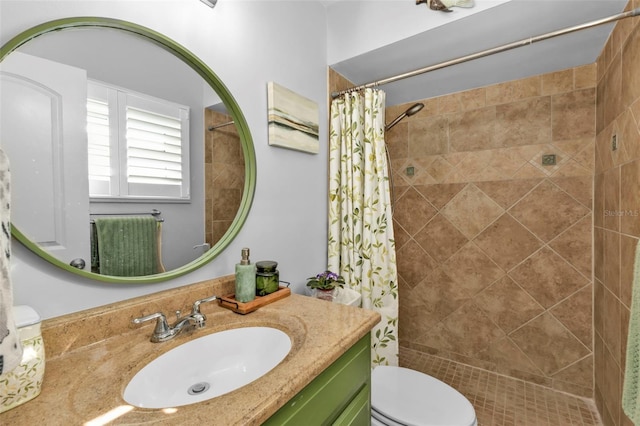 bathroom with vanity, toilet, and tiled shower