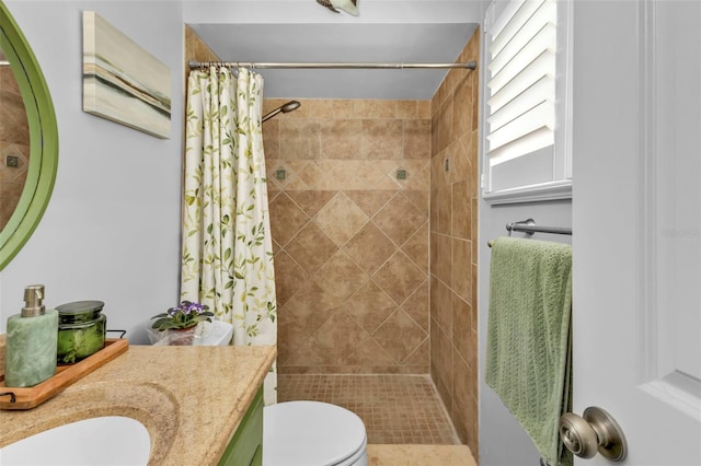 full bath featuring vanity, toilet, and a tile shower