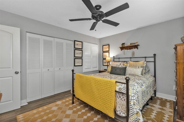 bedroom with ceiling fan, a closet, baseboards, and wood finished floors