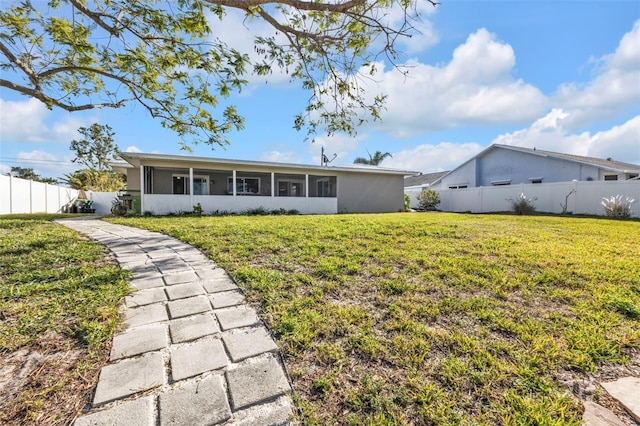 back of property featuring a yard, fence, stucco siding, and a sunroom