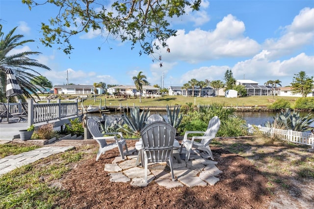 view of yard featuring fence, a water view, a residential view, a patio area, and a boat dock