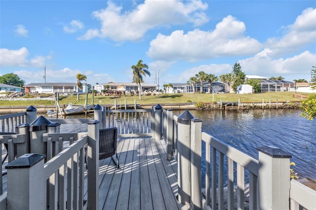 view of dock featuring a yard, a water view, and a residential view