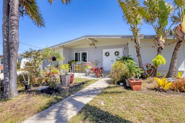 view of front of property featuring stucco siding and a front yard