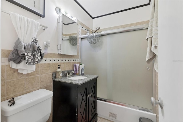 full bath with vanity, visible vents, tile walls, toilet, and combined bath / shower with glass door