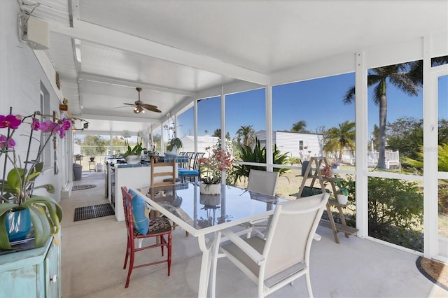 sunroom with beam ceiling and a ceiling fan