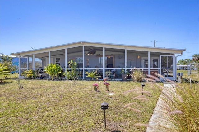 back of property with a lawn and a sunroom