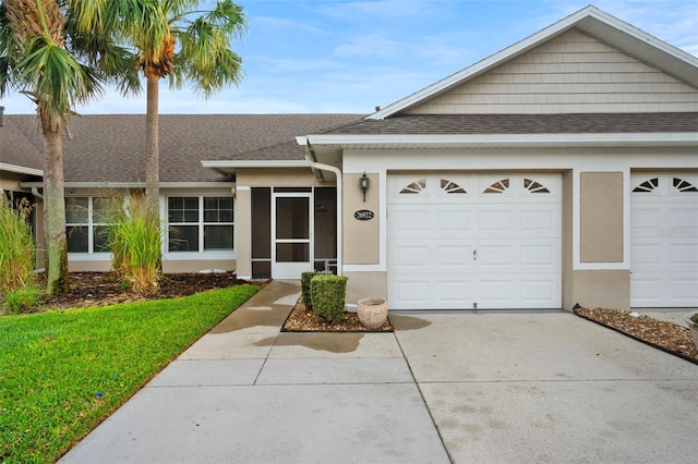 ranch-style home with stucco siding, a garage, driveway, and a shingled roof