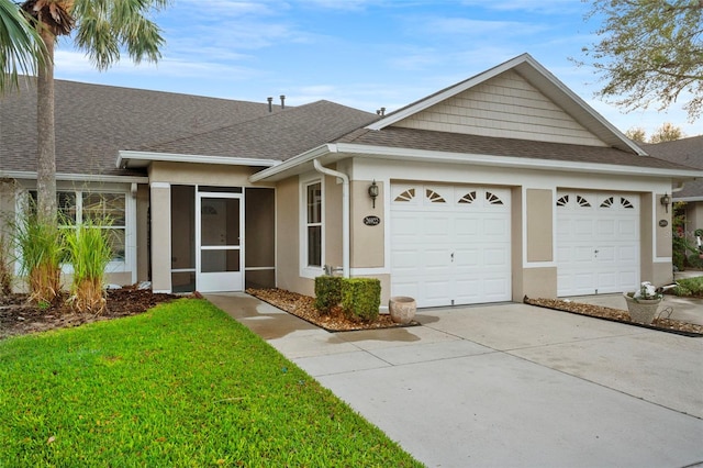 ranch-style house featuring a shingled roof, concrete driveway, a front yard, stucco siding, and an attached garage