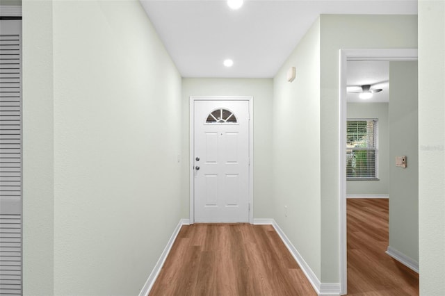 doorway featuring baseboards and wood finished floors