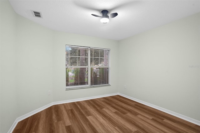 unfurnished room featuring visible vents, a ceiling fan, a textured ceiling, wood finished floors, and baseboards