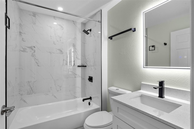 bathroom featuring vanity, shower / tub combination, toilet, and a textured wall