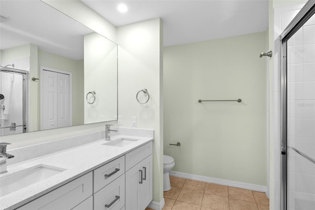 full bath featuring a sink, tiled shower, toilet, and tile patterned floors