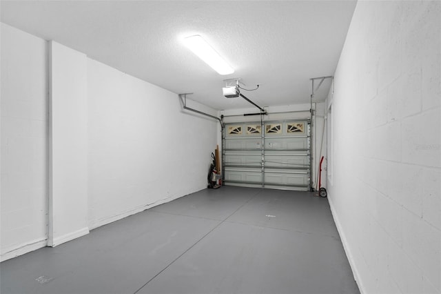 garage featuring a garage door opener and concrete block wall