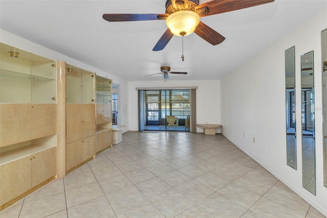 empty room featuring light tile patterned floors and ceiling fan