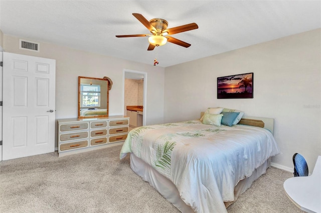 bedroom with a ceiling fan, carpet, visible vents, and ensuite bathroom