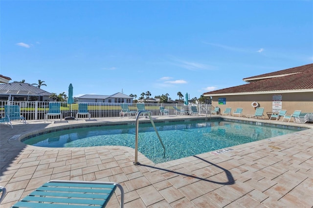 pool with a patio and fence