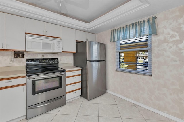 kitchen with white cabinets, light countertops, stainless steel appliances, wallpapered walls, and ornamental molding