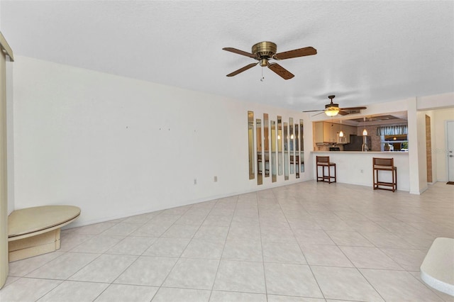 unfurnished living room featuring ceiling fan and light tile patterned floors