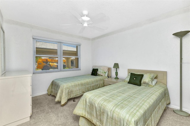 bedroom with a ceiling fan, baseboards, and light carpet