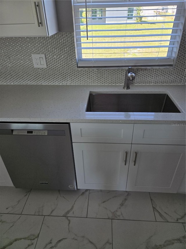 kitchen featuring a sink, marble finish floor, dishwasher, and white cabinetry