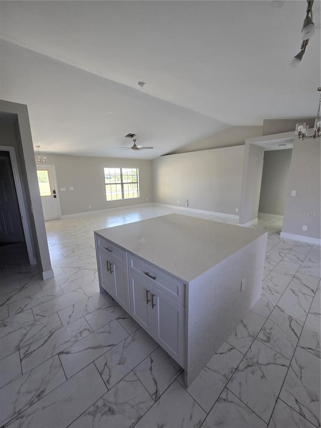 kitchen with ceiling fan, marble finish floor, open floor plan, and white cabinets