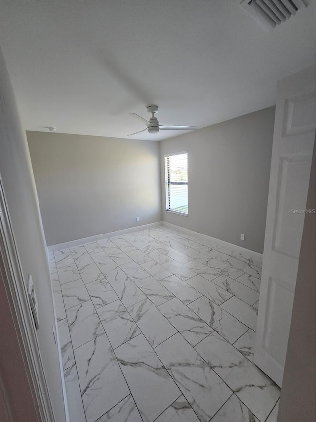 unfurnished room featuring visible vents, marble finish floor, a ceiling fan, and baseboards