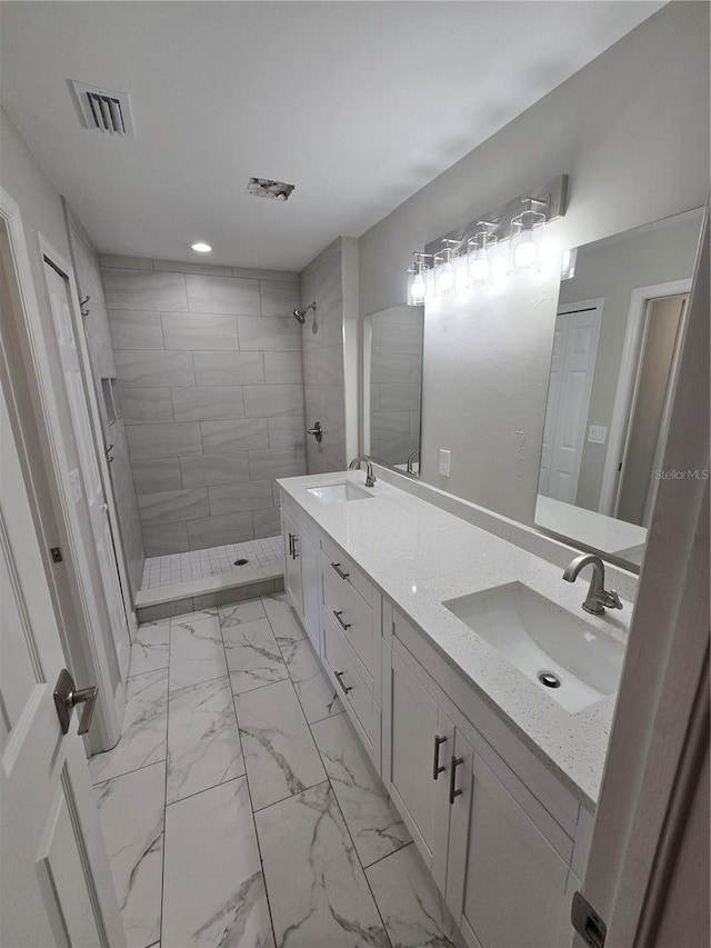 full bath featuring a sink, visible vents, tiled shower, and marble finish floor