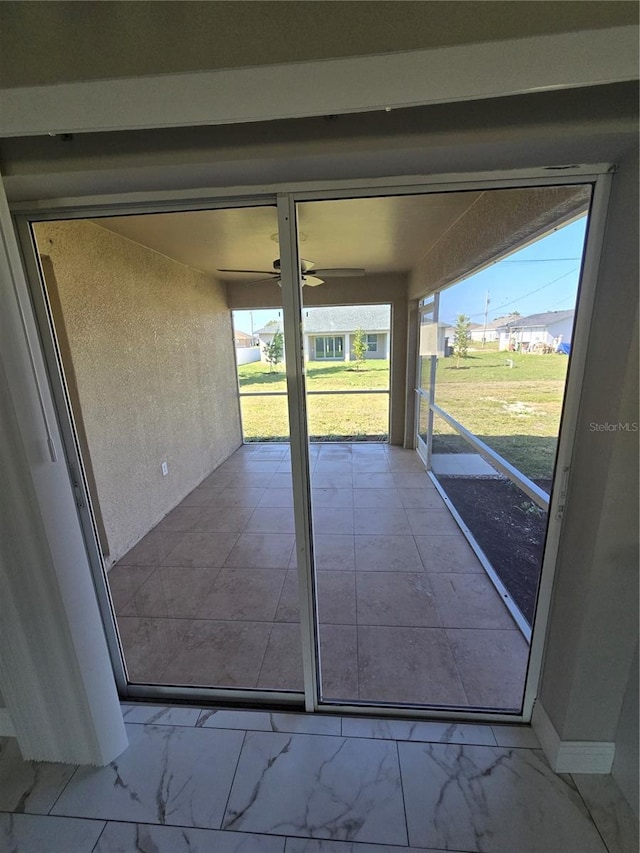 unfurnished sunroom featuring a ceiling fan