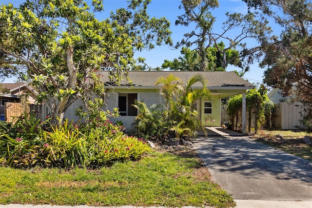 view of front of home featuring an attached carport, driveway, and fence