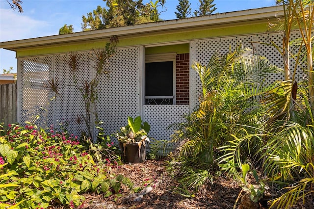 view of home's exterior with brick siding and fence