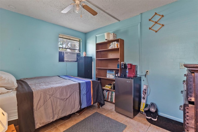 bedroom with a ceiling fan, a textured ceiling, freestanding refrigerator, cooling unit, and light tile patterned flooring