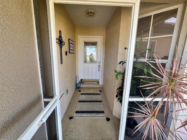 doorway to property featuring stucco siding