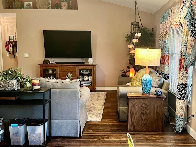 living room featuring baseboards, dark wood finished floors, and vaulted ceiling