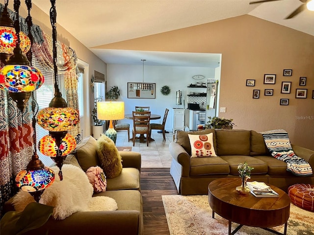 living room featuring wood finished floors, ceiling fan, and vaulted ceiling