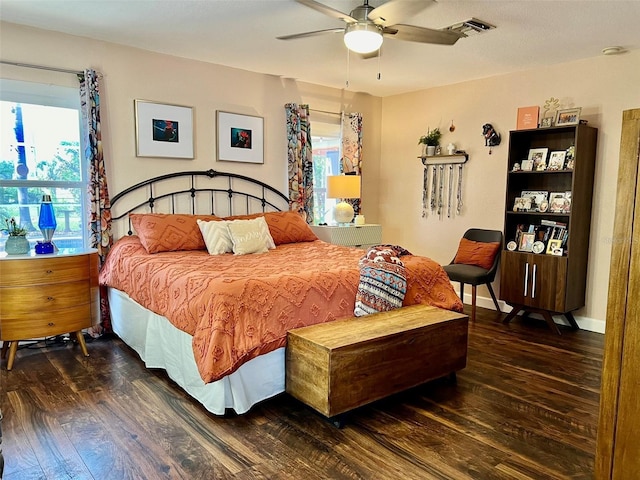 bedroom featuring ceiling fan, wood finished floors, visible vents, and baseboards