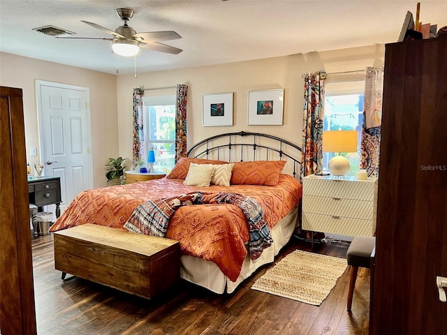 bedroom with visible vents, multiple windows, a ceiling fan, and wood-type flooring