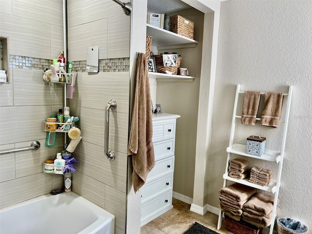 bathroom featuring tile patterned floors, baseboards, and a textured wall