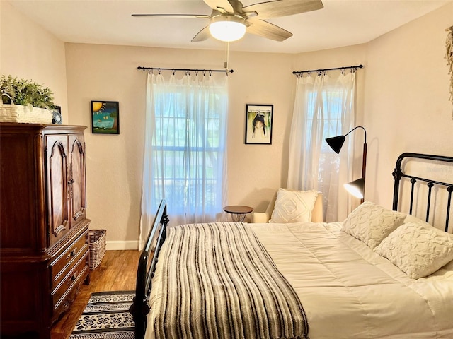 bedroom featuring a ceiling fan, dark wood-type flooring, and baseboards