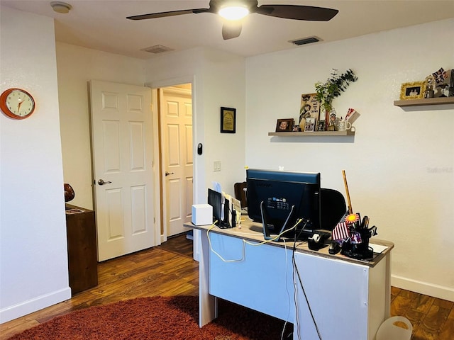 home office with visible vents, dark wood-style flooring, and ceiling fan