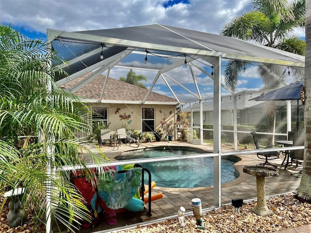 pool with glass enclosure and a patio area