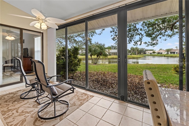 sunroom / solarium with a water view, a healthy amount of sunlight, and a ceiling fan