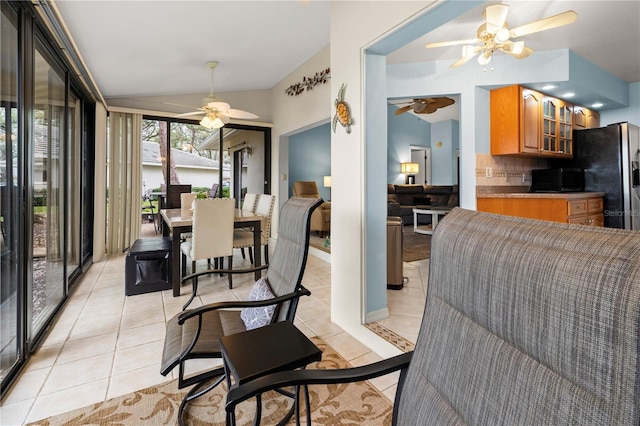 dining space featuring lofted ceiling, light tile patterned floors, and ceiling fan