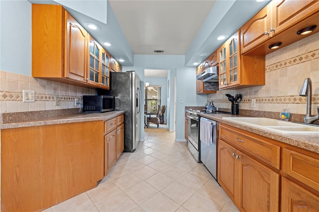 kitchen with a sink, extractor fan, glass insert cabinets, and stainless steel appliances