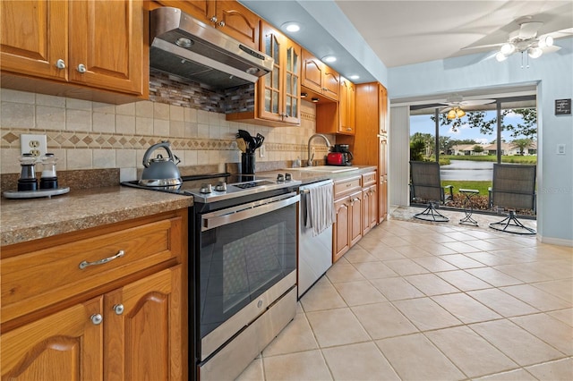 kitchen featuring decorative backsplash, appliances with stainless steel finishes, ventilation hood, and a sink