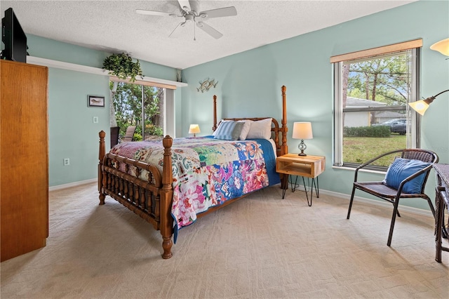 bedroom with multiple windows, baseboards, carpet floors, and a textured ceiling