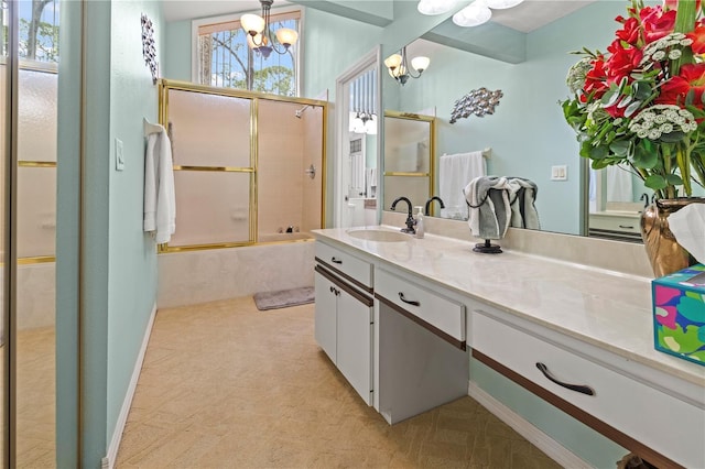 full bathroom featuring combined bath / shower with glass door, a chandelier, and vanity