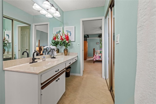 bathroom with vanity, tile patterned floors, baseboards, and a textured ceiling