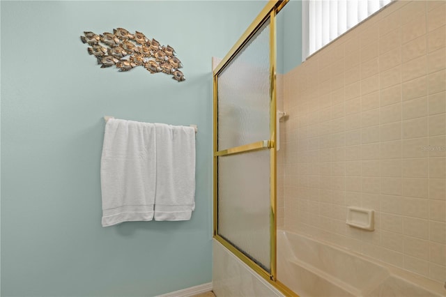 bathroom with bath / shower combo with glass door