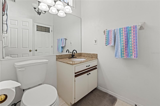 bathroom with baseboards, toilet, an inviting chandelier, tile patterned floors, and vanity